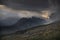 Epic stunning Autumn landscape image of Snowdon Massif viewed from shores of Llynnau Mymbyr at sunset with dramatic dark sky and