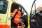 Epic superhero shot: Serious female paramedic sits at ambulance vehicle ready for action