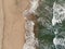 Epic Vertical aerial drone view of waves motion on multicolored sandy beach