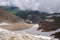 Epic view of the mountain gorge with glaciers, covered with clouds.