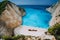 Epic view of Shipwreck middle of sandy Navagio beach surrounded by azure deep turquoise sea saltwater and huge white