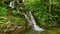 Epic Waterfall in the summer forest. Mountain stream nature background