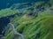 Epic winding road on Transfagarasan pass in Romania in summer time, with twisty road rising up. Road crossing Fagaras mountain