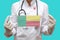 Epidemic in Benin. Young woman doctor in a medical coat or suit and gloves holds a medical mask with the print of the flag of