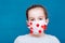 Epidemic covid-19. A girl in a medical mask encircled by a coronavirus on a blue background. Infecting children