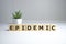 epidemic word written on wood block. epidemic text on wooden table for your desing, coronavirus concept top view