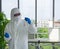 Epidemiological researcher in virus protective clothing use dropper to fill red liquid chemical into test tube. Coronavirus