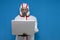 Epidemiologist in a chemical protective suit holds a laptop on a blue isolated background, man, biologist, scientist, virologist