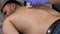 Epilation of the back in men with wax. Middle-aged man suffers pain while epilating in a beauty salon.