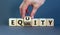 Equality or equity symbol. Businessman turns a cube and changs the word `equality` to `equity`. Beautiful grey background.