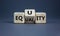 Equality or equity symbol. Turned a cube and changed the word `equality` to `equity`. Beautiful grey background. Psychology,