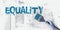 Equality word painted with paintbrush in teal blue. Gender or ethnical equality concept
