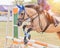 Equestrian rider horse jumping over hurdle obstacle during dressage test competition