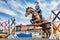 Equestrian sport. Show jumping competition. Young rider horseback girl jumping over an obstacle