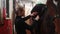 Equestrian sport - a woman in black clothes installing a black leather saddle on horse