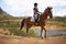 Equestrian, woman and riding a horse in nature on adventure and journey in countryside. Ranch, animal and rider outdoor