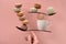 Equilibrium concept flat lay on coral color paper with macarons and spoons