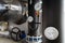 The equipment of the boiler-house, - valves, tubes, pressure gauges, thermometer. Close up of manometer, pipe, flow meter, water