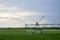 Equipment for irrigation of plants works a green field on a hot day