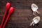 Equipment for rhythmic gymnastics. Clubs and gymnastics shoes on dark wooden background top view copy space