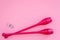 Equipment for rhythmic gymnastics. Clubs on pink background top view copy space