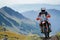 An equipped motorcyclist makes a race in a mountainous landscape. The concept of motorsport