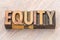 Equity word abstract in wood type