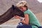 Erfoud, Morocco - Oct 17, 2019: A tourist girl cuddling up to a dromedary in the Sahara desert between Midelt and Erfoud