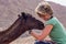 Erfoud, Morocco - Oct 17, 2019: A tourist girl cuddling up to a dromedary in the Sahara desert between Midelt and Erfoud