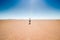 Erg Chigaga, Morocco - October 09, 2013. Man in hat walking on dry lake Iriki in Sahara Desert