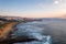 Ericeira drone aerial view on the coast of Portugal with surfers on the sea at sunset