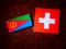 Eritrean flag with Swiss flag on a tree stump