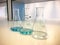 Erlenmeyer flasks on bench in chemistry laboratory with blue solvent indicator, titration water sample.