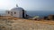 Ermida da Memoria, white chapel with a pointed dome, on the edge of a coastal cliff, Cabo Espichel, Portugal