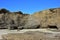 Eroded Rocky Cliff On Sandy Beach