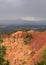 Eroding cliffs of orange and yellow topped with green pines under a softly raining cloudy sky in Bryce Canyon