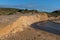 An eroding sand bank on the coast of Cornwall in bright sunshine