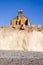 Erosion, Side of a terraced house sitting on edge of a white chalk cliff face with pebble beach beneath with eroded boulders on t