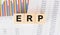 ERP word written on wood block. Faqs text on table, concept