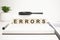 errors word concept. wooden cubes, notepad, pen and business charts