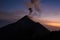 Eruption with incandescent material and lava from the volcano seen from the camp area when it is dusk and the light is dim