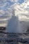 Eruption of Strokkur geyser in Iceland. Spring evening sun coming through the steam.