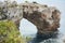 Es Pontas in Mallorca with boat anchored nearby in the Mediterranean sea. Majorca Sunrise with yacht and rock arch near Santanyi.