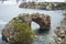 Es Pontas in Mallorca with boat anchored nearby in the Mediterranean sea. Majorca Sunrise with yacht and rock arch near Santanyi.