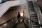 Escalator system. A guy in an empty large building descends on an escalator instead of steps