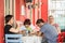 Eskisehir, Turkey - June 14, 2017: Group of bored friends sitting in a cafeteria, drinking water and tea, talking on the phone.