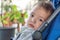 Eskisehir, Turkey - June 15, 2017: Sleepy baby boy with brown eyes in blue stroller looking at the camera in a cafe.