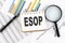 ESOP text on notebook on the graph background with pen and magnifier