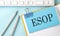 ESOP text on sticker on the blue background with pen and keyboard