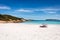 Esperance, Australia - Mar 17, 2021: Holiday makers relax under an umbrella on the prisitine white sand beach and sparkling waters